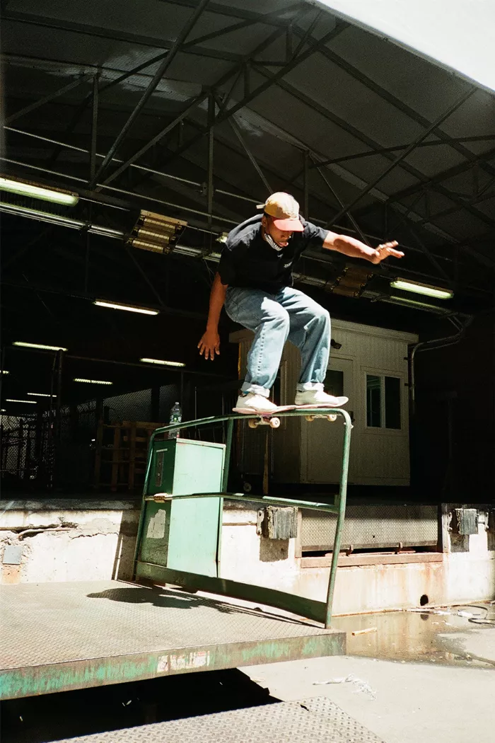 Christian performing a boardslide at an adjustable shipping container rail in Union Square.