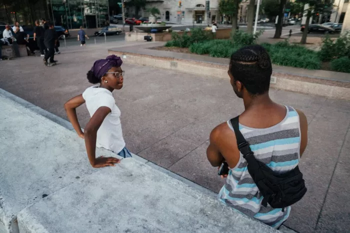 Close-up shot of Darren Harper smiling while watching his daughter, Demi, perform a trick on her skateboard.