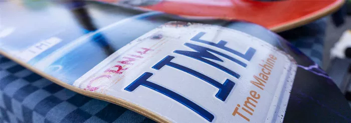 Close-up shot of skateboard decks stacked on top of each other, showing their varying colors and graphics