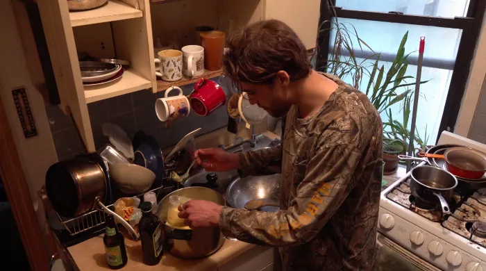 Close-up shot of Yaje Popson preparing Brazilian cheese bread dough in a mixing bowl.