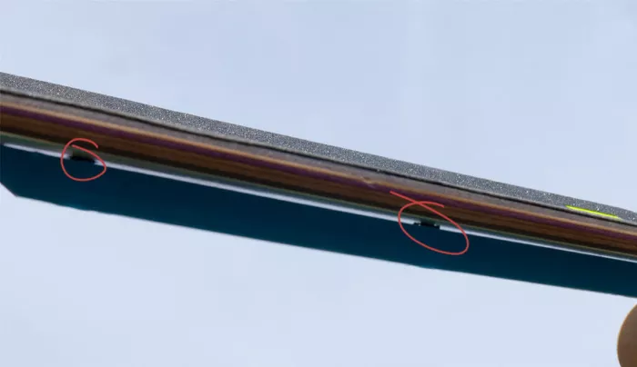 Close-up showing the space between two skateboard deck rails, illustrating their typical placement on the deck