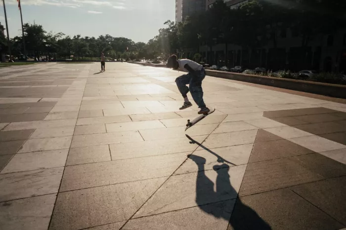 Darren Harper skating alongside his two daughters, Tink and Demi, at a skatepark.