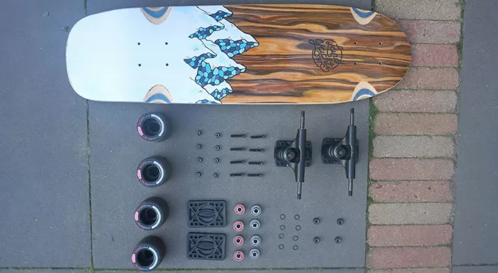 Disassembled dedicated cruiser board showing deck, trucks and wheels