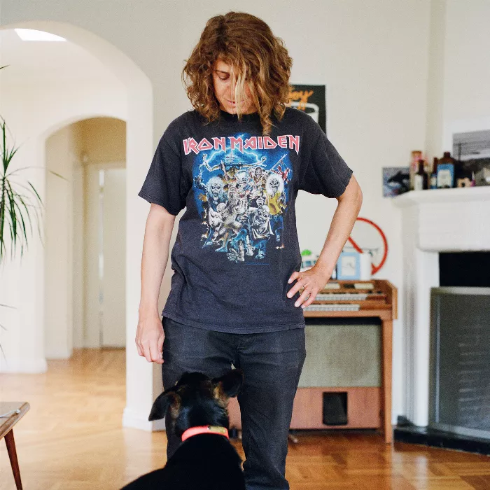 Elissa Steamer pictured from the shoulders up, wearing a black t-shirt, looking off to the side with a serious expression on her face.