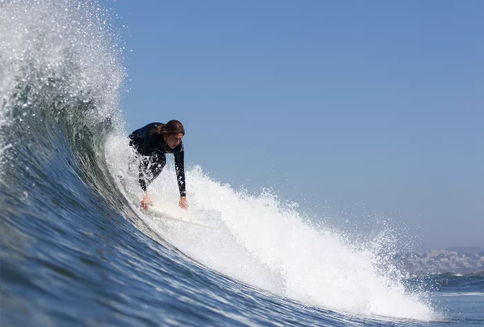 Elissa Steamer pops up on a surfboard mid-wave.