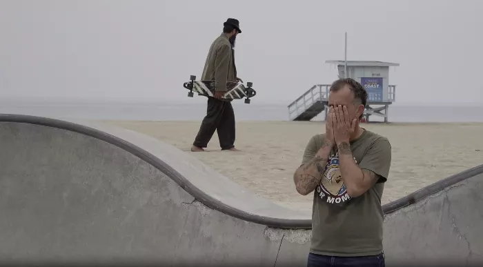 Frank performing a magic trick on the Santa Monica Pier, entertaining onlookers.