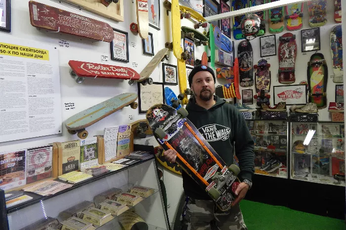 Gleb Bentsiovski standing in front of his USSR skateboard museum