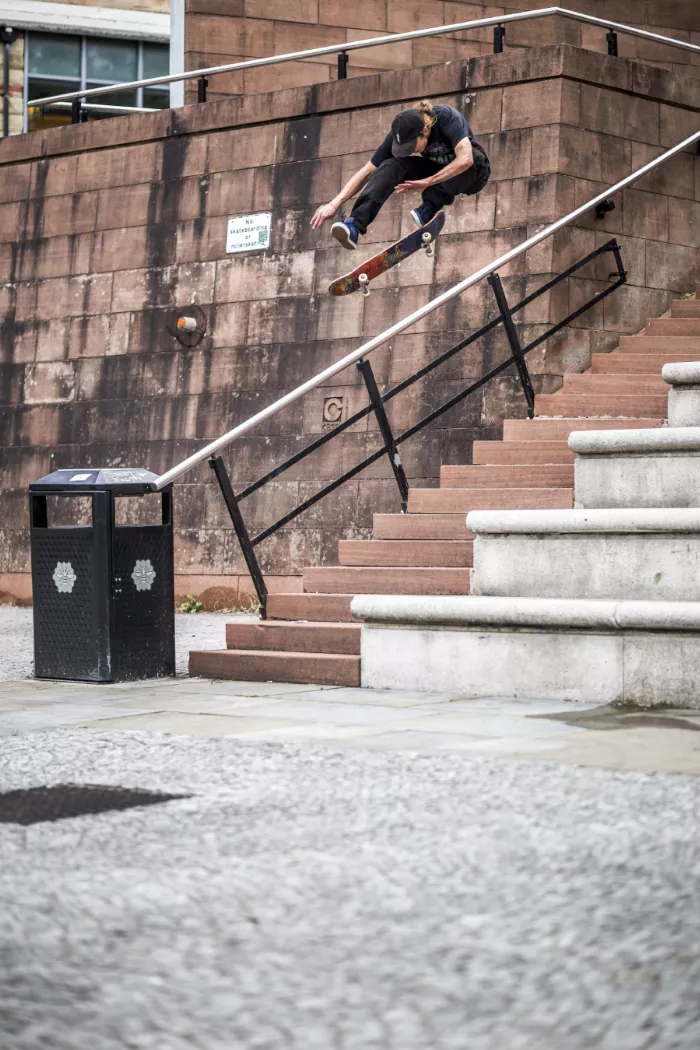 Jiri Bulin performs a heelflip on a cobblestone street