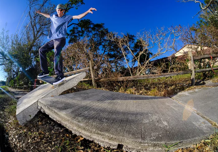 Kevin McGovern performs a nose manual on a longboard. The photo is taken from a low angle, emphasizing the board and the skater's posture.