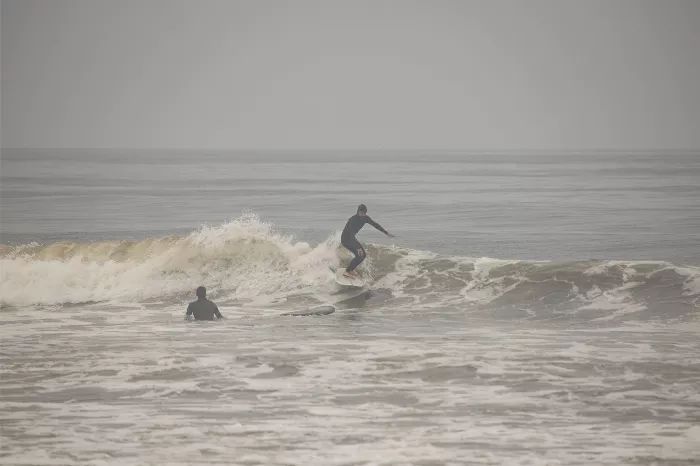 Max Schaaf surfing, pictured from the waist up, mid-turn.