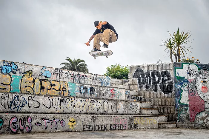 Nicolas Garay holding his magazine in front of a graffitied wall.