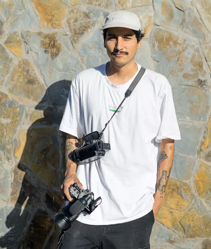 Nicolas Garay looking at the camera with a skateboard in the background.