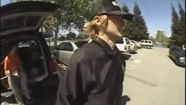 Owen Wilson casually sitting on a car bumper