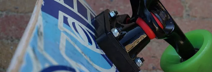 Riser pads attached to skateboard trucks, highlighting their placement between the deck and trucks