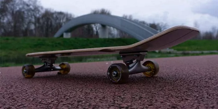 Side view of Arbor Oso Foundation cruiser with light blue wheels and natural wood deck