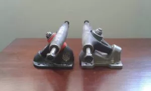 Split longboard trucks show different baseplate angles, where the lower angled truck hanger is closer to parallel with the ground