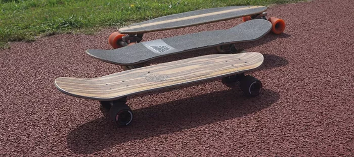 Three different cruiser skateboard setups, one with larger soft wheels, another with smaller harder wheels and a third dedicated cruiser board