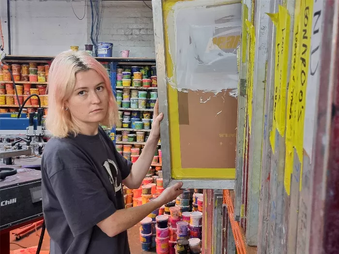 Tobi Stanley screen printing a design.