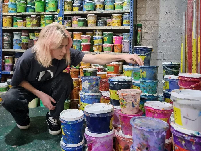 Tobi Stanley with various colorful skateboards.