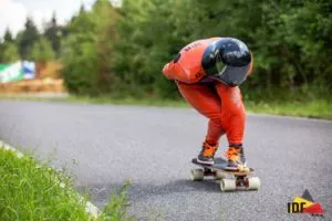 Two downhill skateboarders wearing New Olders aero helmets