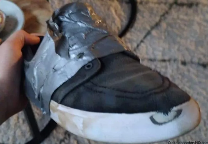 Using duct tape to repair skate shoes, showcasing a quick and easy temporary fix