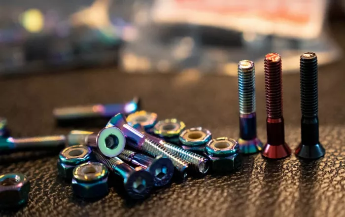 Various sizes of skateboard hardware displayed, including different bolt head types