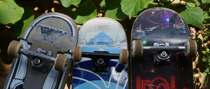 Various skateboard decks and components laid out on a wooden surface