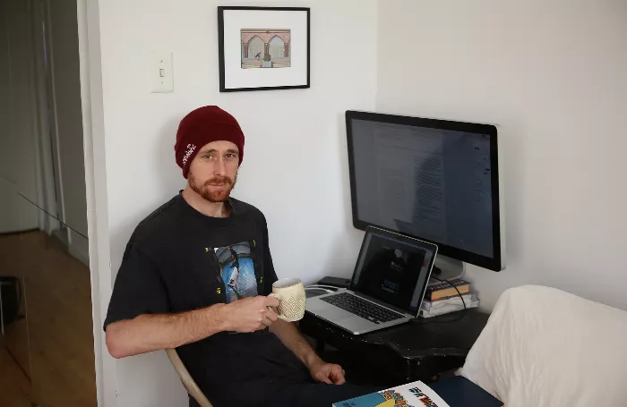 Walker Ryan, a pro skateboarder, stands holding his book &quot;Top of Mason.&quot;