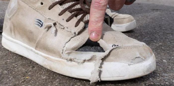 Worn skate shoes with holes near the ollie area